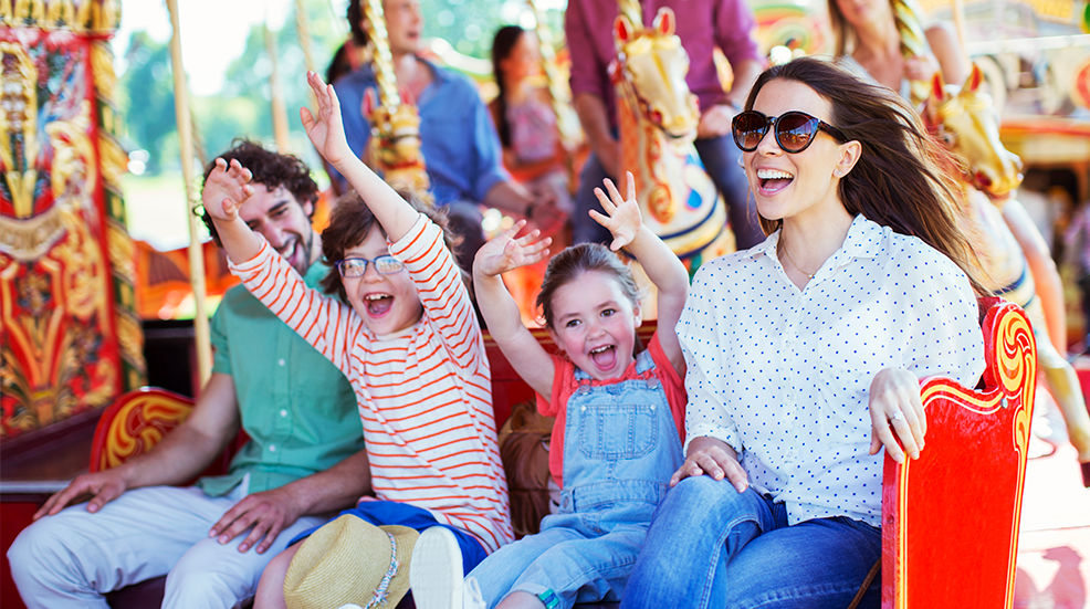Family on carousel in amusement park